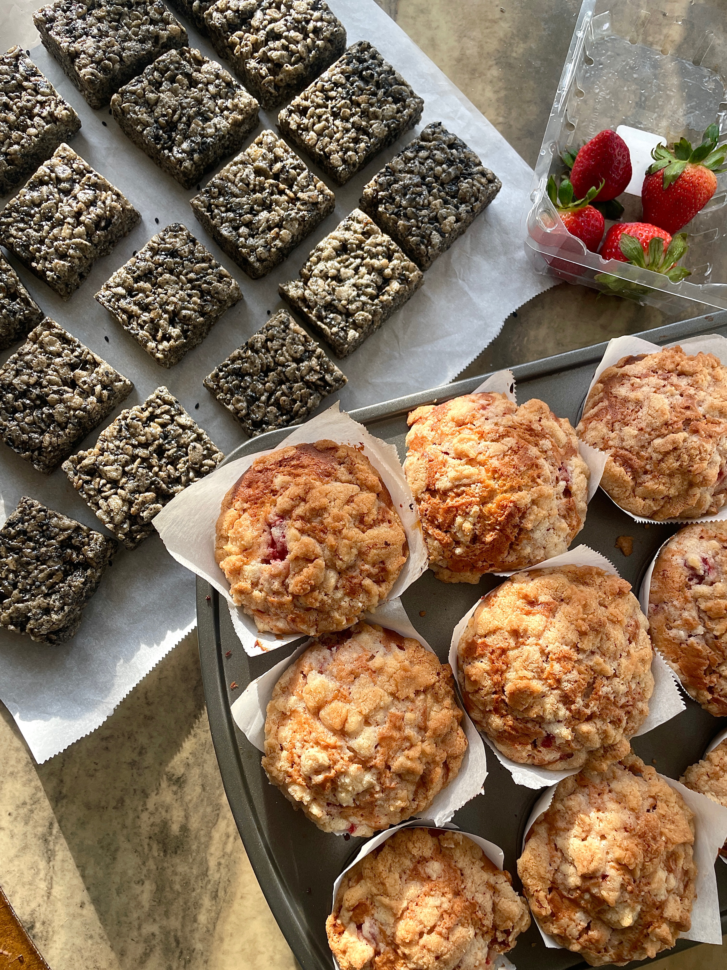 Trays of baked miso sesame rice crispy squares and fruit muffins.