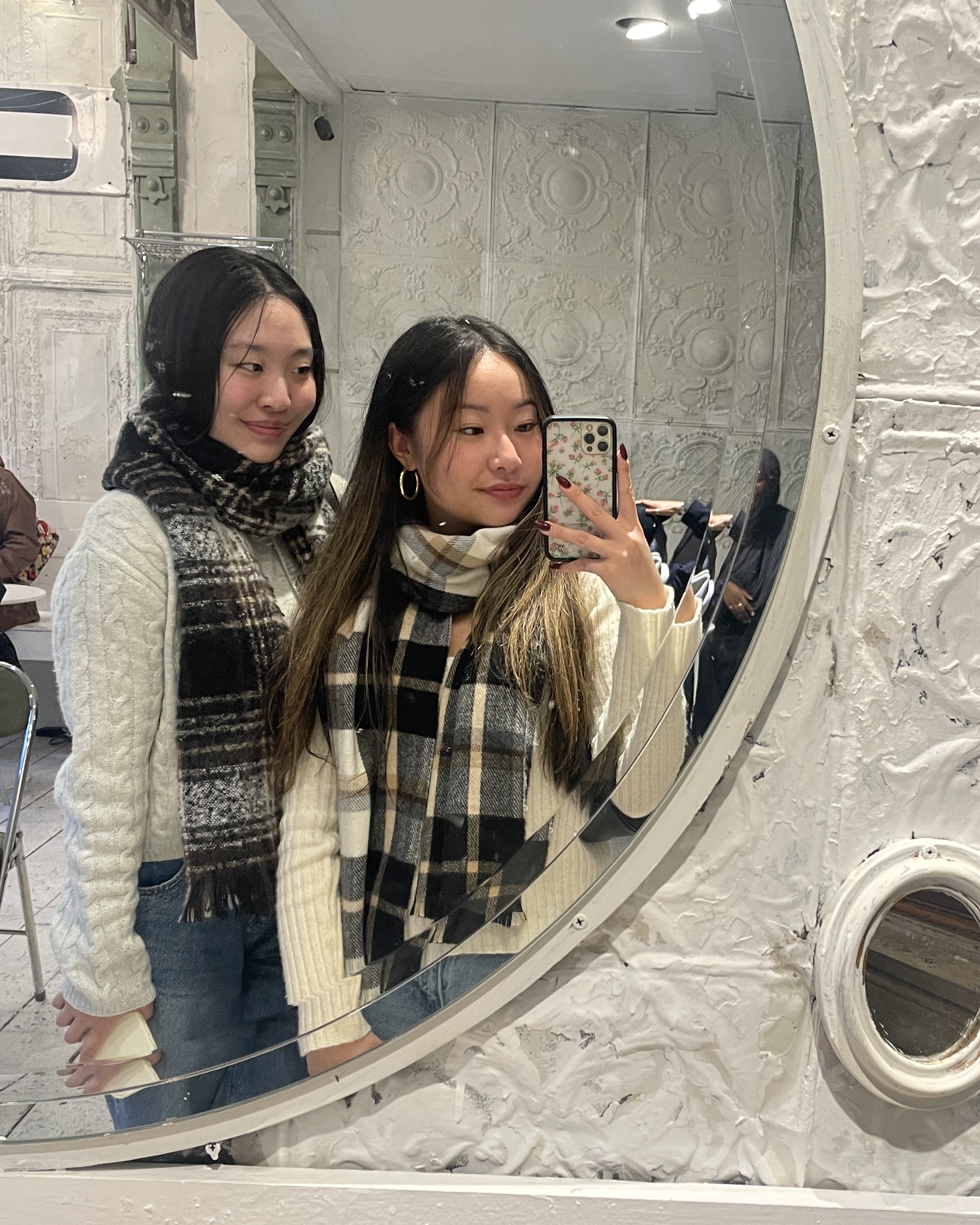 Tina and a friend taking a mirror selfie.