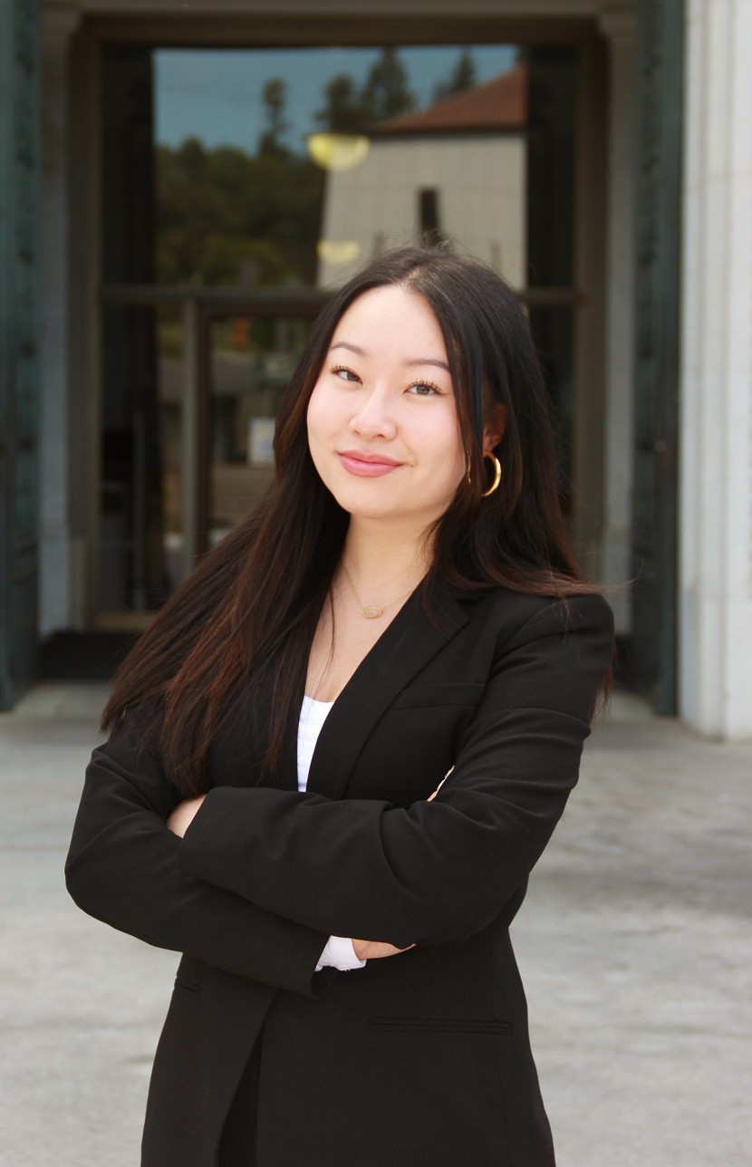 Portrait of Tina Zou standing with her arms crossed outside a UC Berkeley building.